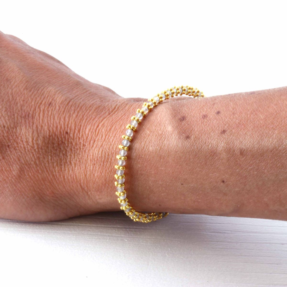 a woman wearing  an aquamarine bracelet on her wrist